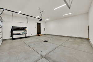 Garage featuring baseboards and a garage door opener