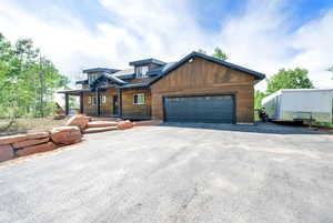 Rustic home with a garage and asphalt driveway