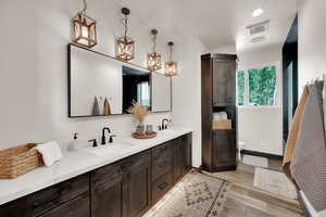 Full bath featuring double vanity, wood finished floors, and a shower with shower door