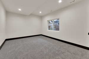 Carpeted spare room with recessed lighting and baseboards