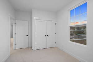 Unfurnished bedroom with carpet and a closet