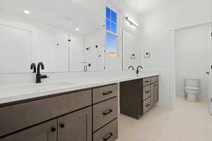 Full bathroom with double vanity, a stall shower, and tile patterned flooring