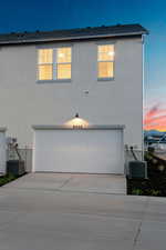 View of front of home featuring an attached garage, stucco siding, and driveway