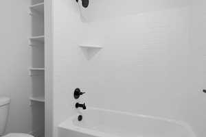 Bathroom with toilet and bathtub / shower combination