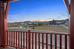 Yard at dusk featuring a balcony, a mountain view, and a residential view