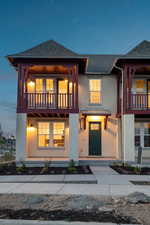 View of front facade featuring stucco siding, a balcony, and a shingled roof