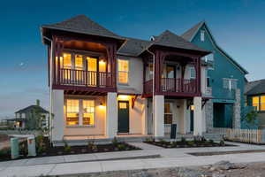 View of front of home featuring a balcony, stucco siding, and roof with shingles