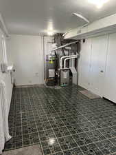 Finished below grade area with secured water heater and a textured ceiling