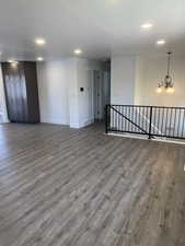 Empty room with wood finished floors, recessed lighting, a textured ceiling, and a chandelier