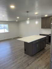 Kitchen with dark wood finished floors, recessed lighting, decorative light fixtures, a center island, and range