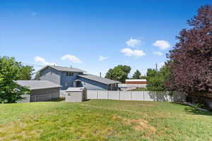 Fenced backyard featuring a storage shed. View to the west.