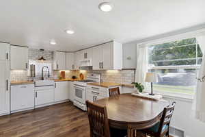 Kitchen featuring white appliances, butcher block counters, plenty of natural light, and white cabinets
