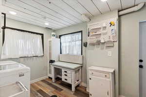 Laundry room, light wood-style floors, and recessed lighting. Drain in floor. Bright natural lighting. Access to back patio and yard.