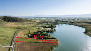 Aerial view of property and surrounding area featuring property parcel outlined and a water and mountain view