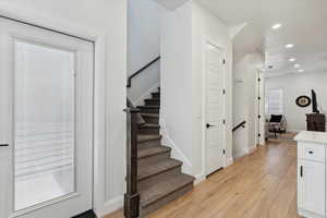 Stairs with hardwood / wood-style flooring and recessed lighting