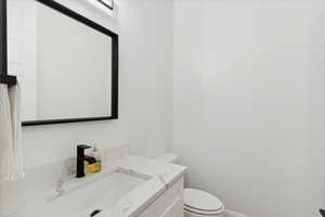 Half bathroom featuring toilet and vanity