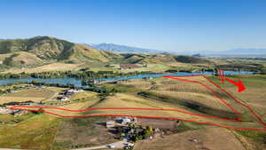Aerial view of property and surrounding area featuring property parcel outlined and a water and mountain view