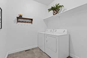 Laundry room featuring baseboards and washing machine and clothes dryer
