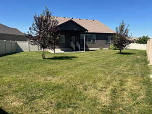 Back of property featuring a fenced backyard, a patio area, and stucco siding