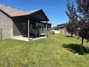 Rear view of house featuring a patio, stucco siding, and roof with shingles