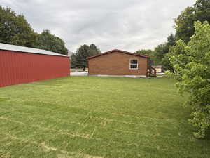View of green lawn featuring an outdoor structure