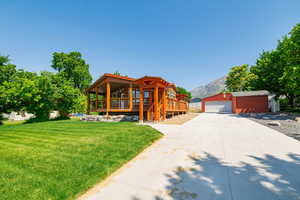 Log home featuring an outbuilding, a front lawn, a garage, and a mountain view