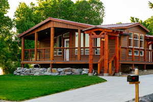 Log home featuring a metal roof, a front yard, and a deck