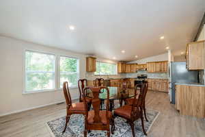 Dining area with light wood-style flooring, lofted ceiling, recessed lighting, and ornamental molding
