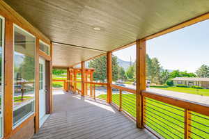 Deck with a mountain view and a lawn
