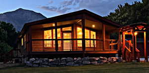 Back of house featuring a mountain view and a lawn