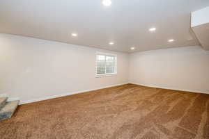 Below grade area featuring carpet floors, recessed lighting, and stairway