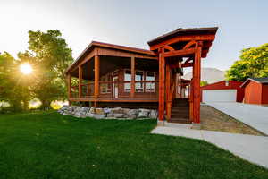 View of front of house featuring an outbuilding, a front yard, a porch, a mountain view, and a garage