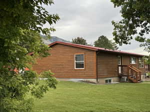 Rear view of house with a yard and a mountain view