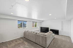 Living room with carpet floors, recessed lighting, and a textured ceiling