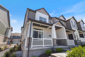 Craftsman-style house with stone siding, covered porch, and stucco siding