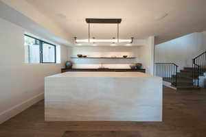 Kitchen with a center island and dark wood-type flooring