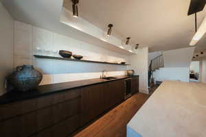 Kitchen with open shelves, dark brown cabinets, wine cooler, and dark wood-type flooring