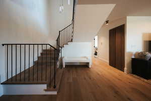 Stairway with wood finished floors and baseboards