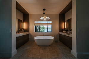 Full bathroom featuring a soaking tub and vanity