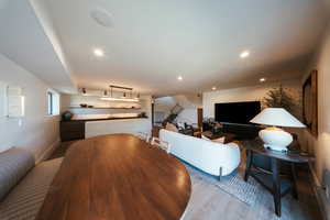 Dining space with wood finished floors, stairs, and recessed lighting