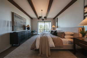 Bedroom with beam ceiling, access to outside, and a chandelier