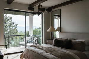 Bedroom with multiple windows, beamed ceiling, access to exterior, and a mountain view