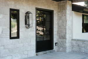 View of exterior entry featuring stone siding