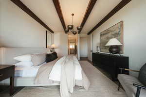 Bedroom with beamed ceiling and a chandelier