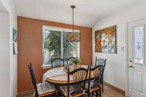 Dining room with healthy amount of natural light, vaulted ceiling, and light tile patterned floors