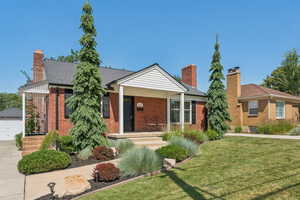 Ranch-style home featuring brick siding, a front yard, and a chimney