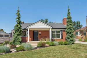 Bungalow-style home featuring brick siding, a chimney, and a shingled roof