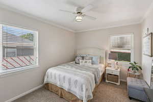 Bedroom with carpet, crown molding, and a ceiling fan