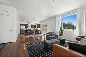 Living room with dark wood finished floors, french doors, and recessed lighting