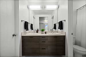 Bathroom featuring double vanity and toilet